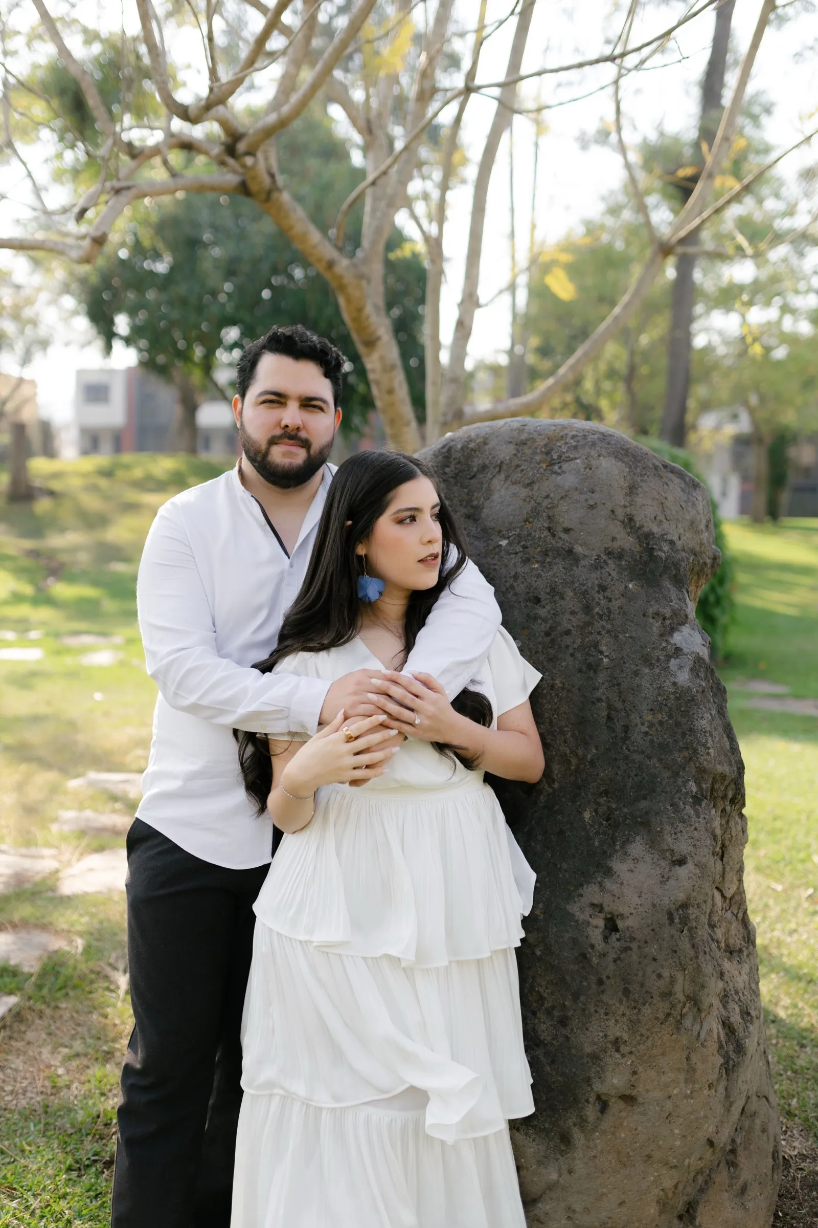 Josué y Katherine de pie, abrazados junto a una roca