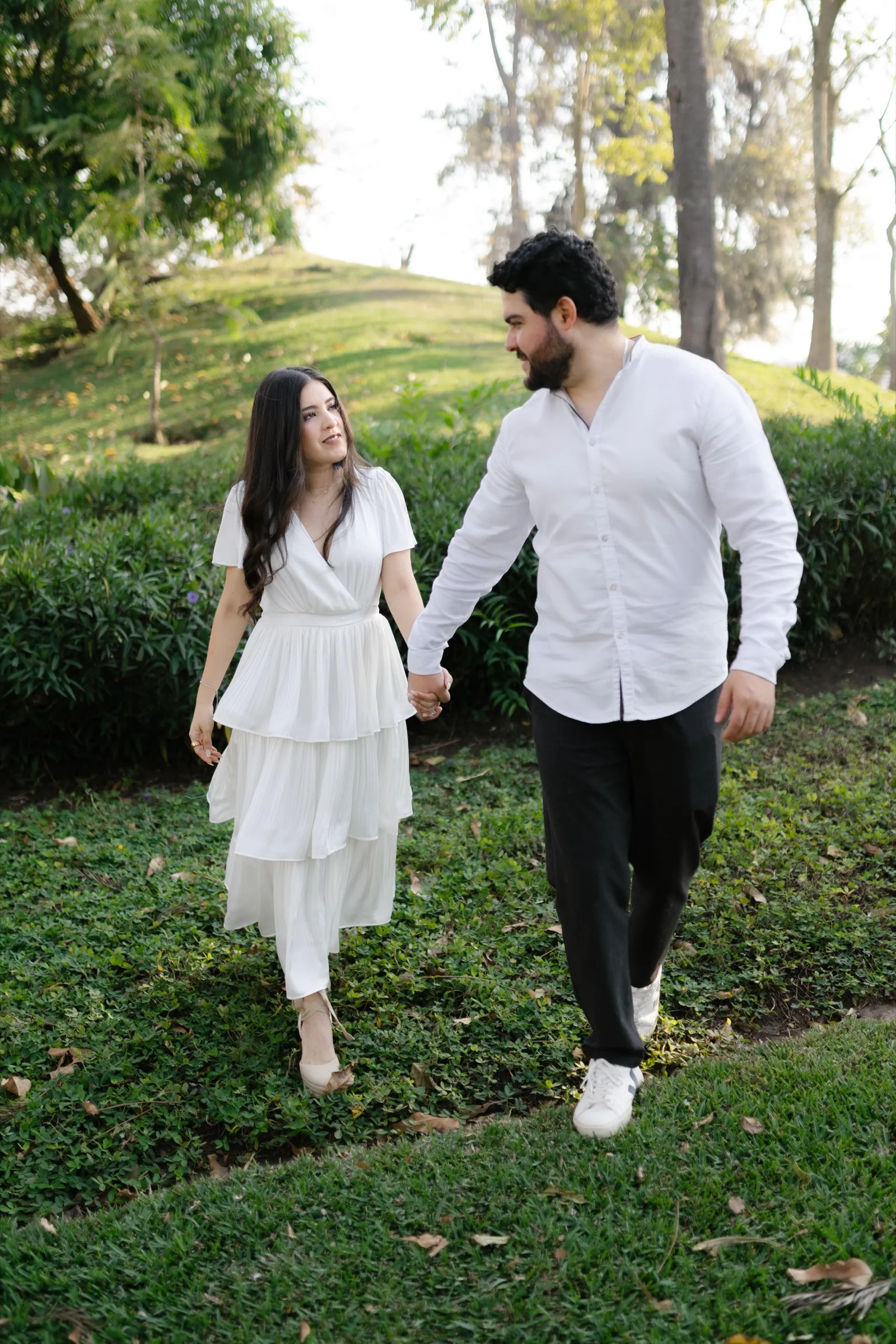 Josué y Katherine caminan tomados de la mano por el jardín